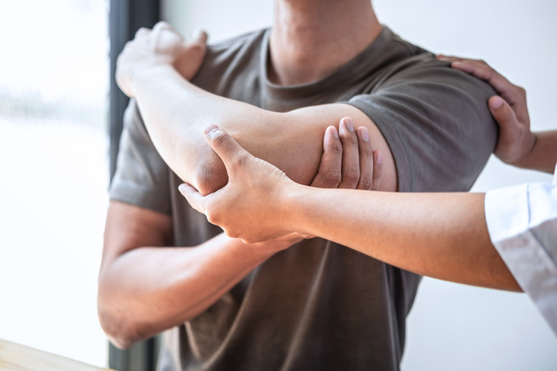 Female Physiotherapist working examining treating injured arm of